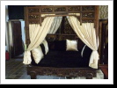 A four poster canopy bed with deep relief carved floating panels